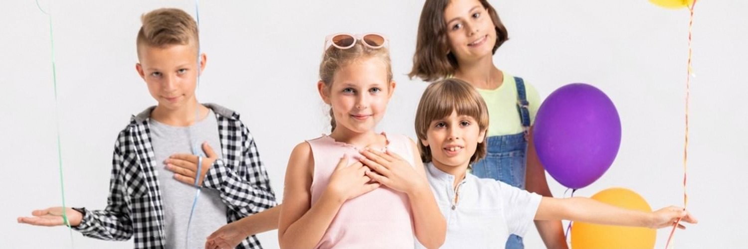 Group of kids posing with balloons at a birthday celebration