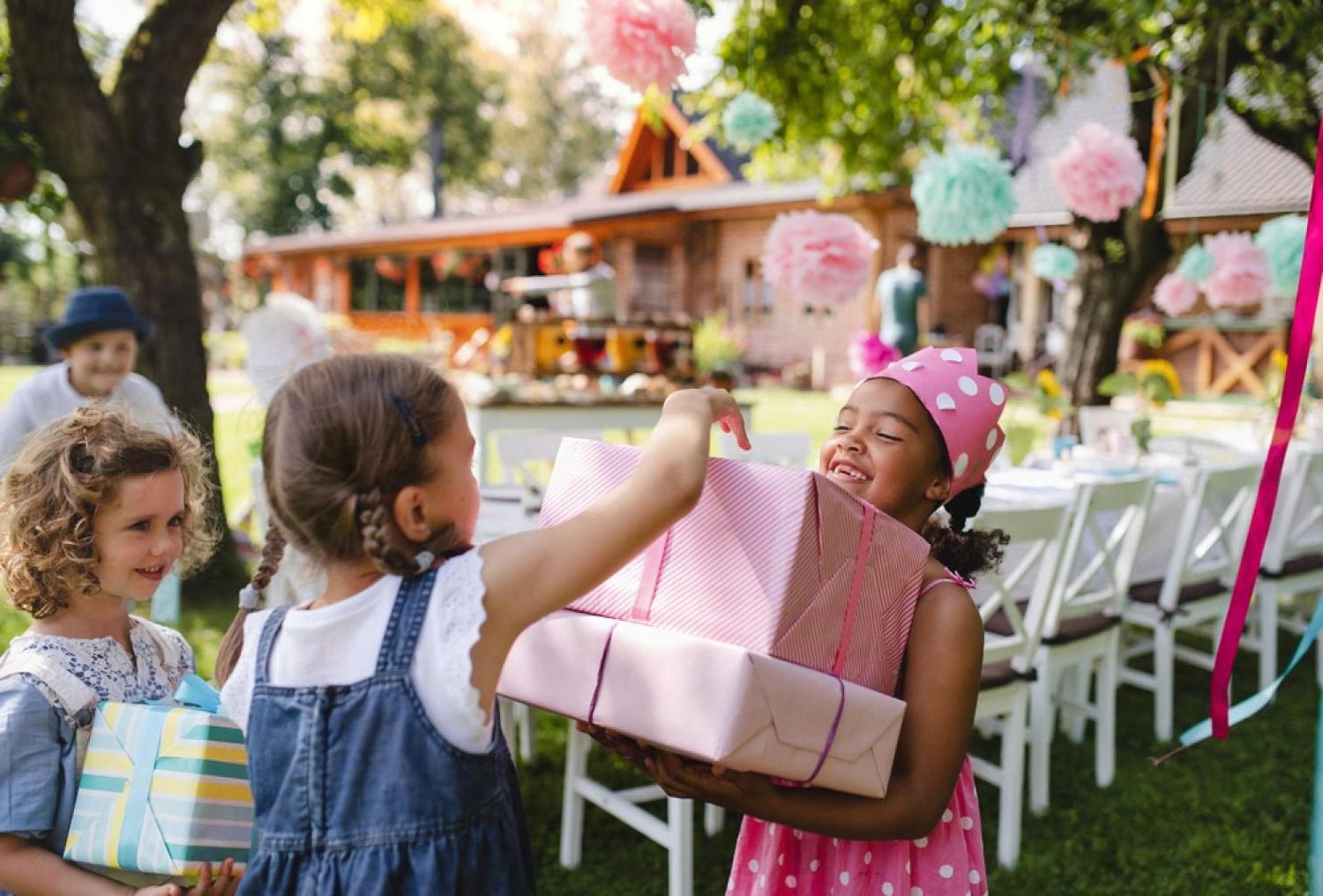 Children exchanging gifts at a decorated outdoor birthday party in the UAE